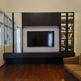 Backdrop TV dengan bingkai putih, kabinet atas hitam, dan lemari pajang di sisi kanan