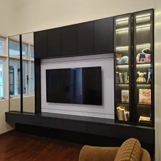Backdrop TV hitam putih dengan lemari pajang kaca berlampu dan kabinet bawah melayang