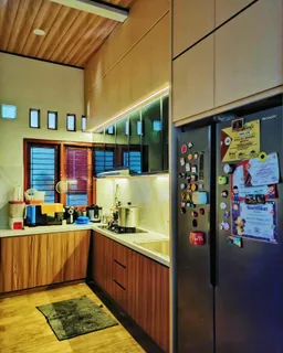 Sudut kitchen set di Bekasi dengan kulkas dan lampu di bawah kabinet