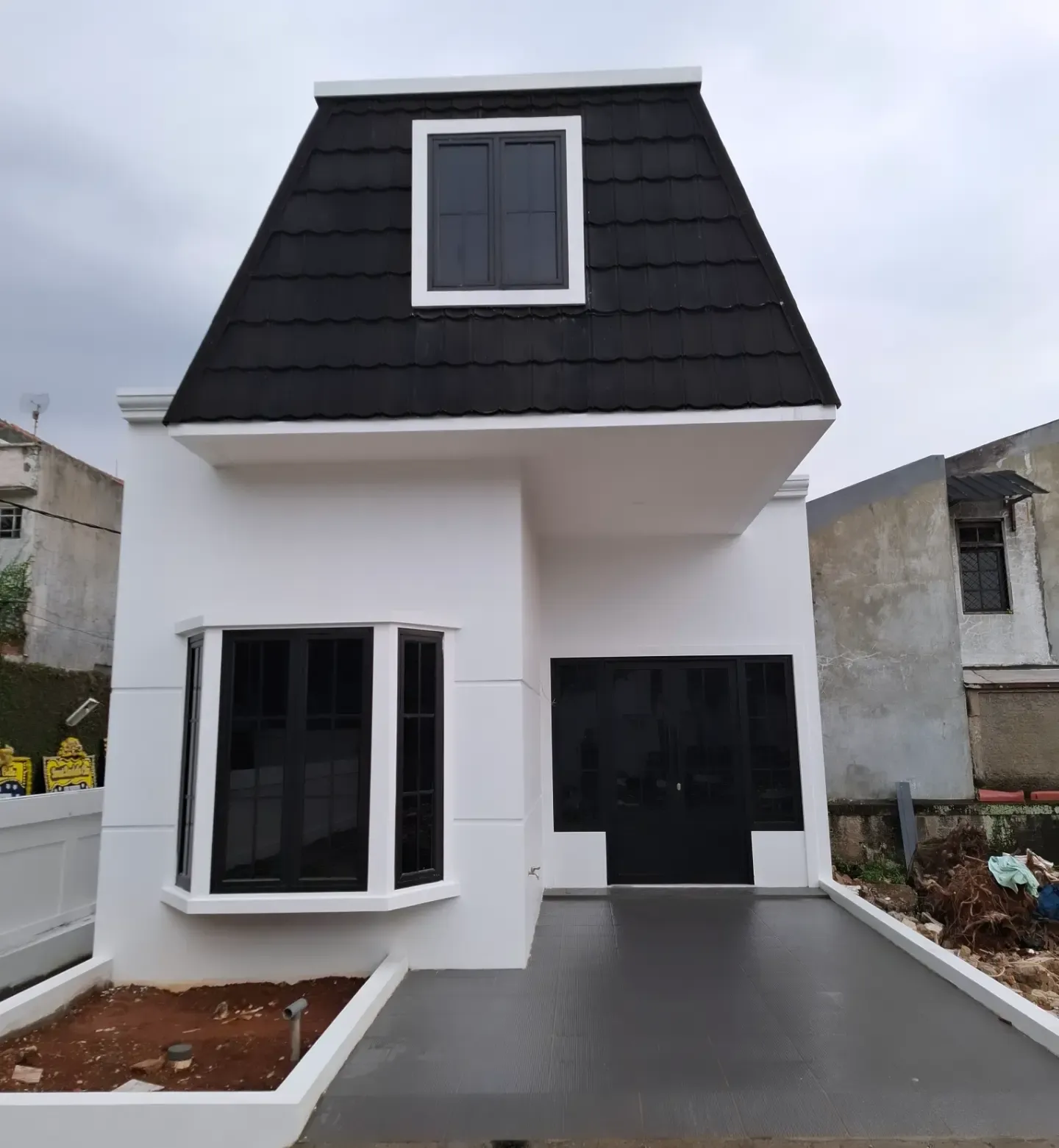 Rumah klasik putih dengan atap mansard hitam dan jendela bay