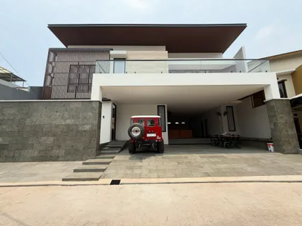 Fasad rumah dua lantai modern kontemporer dengan atap datar, dinding batu alam, dan carport terbuka