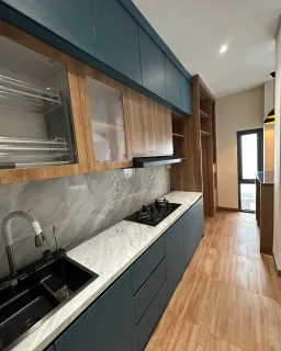 Kitchen set biru tua dan motif kayu dengan kabinet atas kaca dan top table marmer