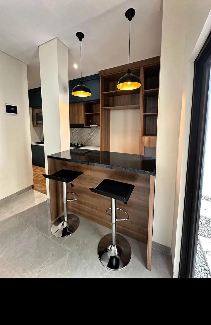 Minibar dengan dua kursi dan lampu gantung di ujung dapur