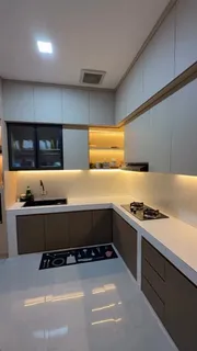 Kitchen set bentuk U di Pamulang dengan kabinet krem dan cokelat serta lampu di bawah kabinet