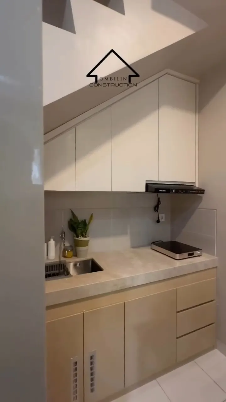 Kitchen set putih di bawah tangga dengan top table motif batu