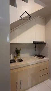 Kitchen set putih di bawah tangga dengan top table motif batu