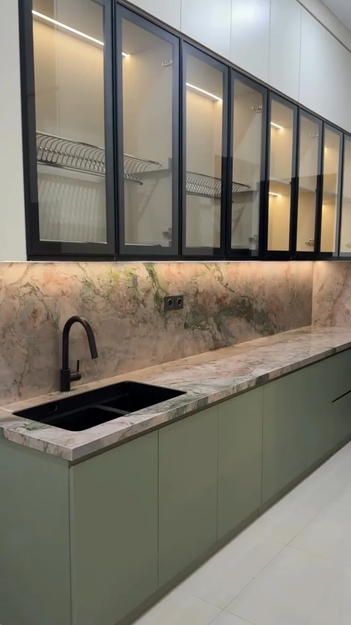 Kitchen set hijau lembut dengan top table sintered stone bermotif dan kabinet atas kaca bingkai hitam