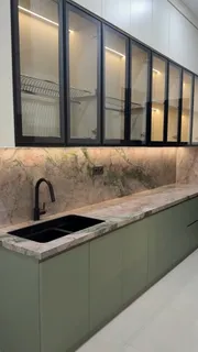 Kitchen set hijau lembut dengan top table sintered stone bermotif dan kabinet atas kaca bingkai hitam
