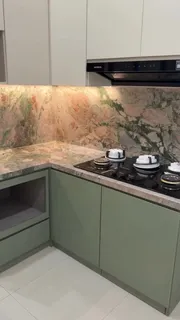 Sudut dapur dengan kompor tanam dan backsplash sintered stone bermotif