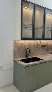 Bak cuci hitam di atas top table sintered stone dengan lampu di bawah kabinet