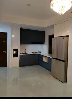 Apartemen Sudirman Park sesudah renovasi, dengan kitchen set gelap berbentuk L dan lantai mengilap