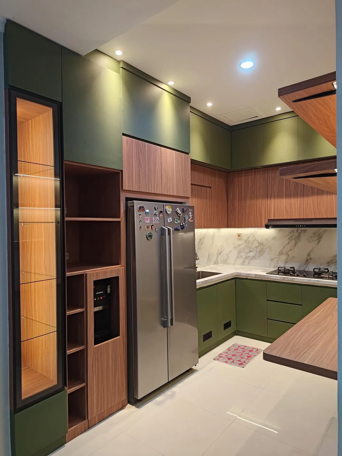 Kitchen set hijau tua dan walnut dengan kulkas dua pintu, lemari kaca berlampu, dan meja lipat