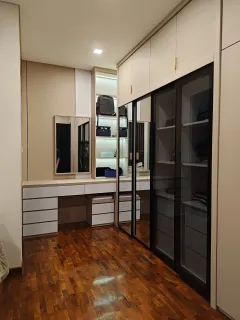 Meja rias dengan cermin dan laci putih di samping wardrobe pintu kaca