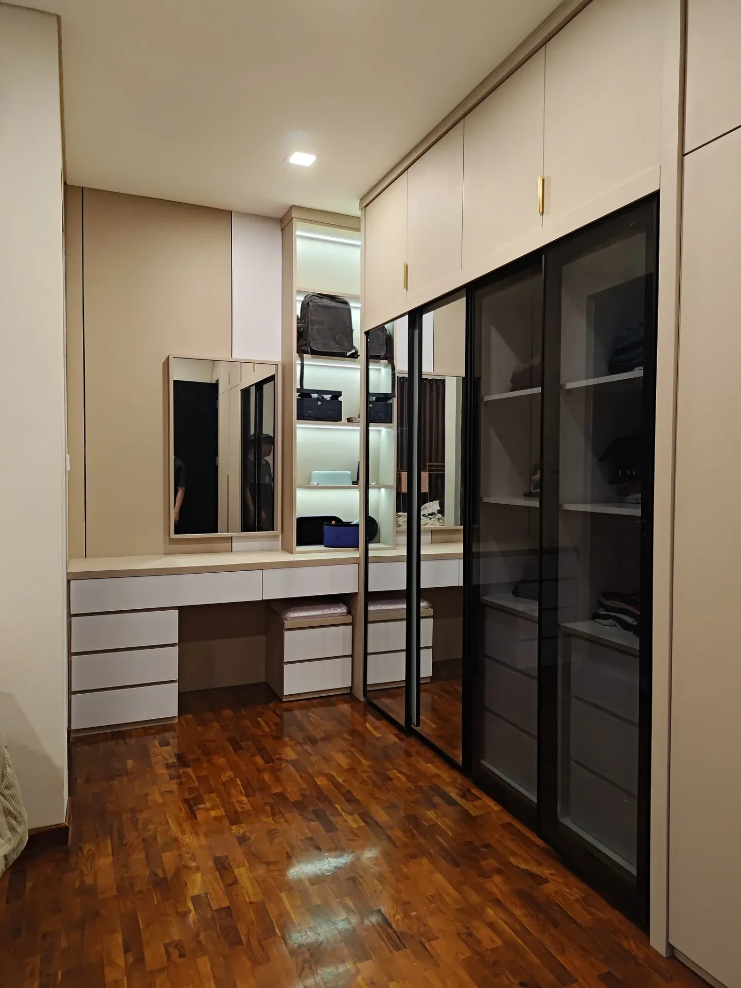 Meja rias dengan cermin dan laci putih di samping wardrobe pintu kaca